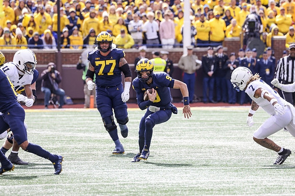 Trevor Keegan (77) and J.J. McCarthy (9)