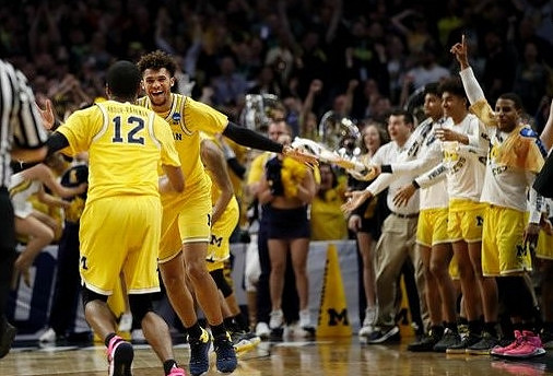Muhammad-Ali Abdur-Rahkman (12), Isaiah Livers (4), and Michigan Team