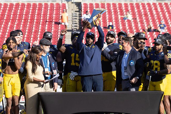 Sherrone Moore, Michigan Team, and ReliaQuest Bowl Trophy