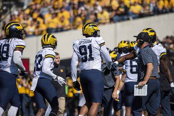 Eyabi Anoma Okie (18), Gemon Green (22), Taylor Upshaw (91), and Jim Harbaugh
