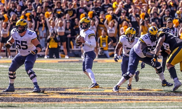 Zak Zinter (65), J.J. McCarthy (9), Donovan Edwards (7), and Olusegun Oluwatimi (55)