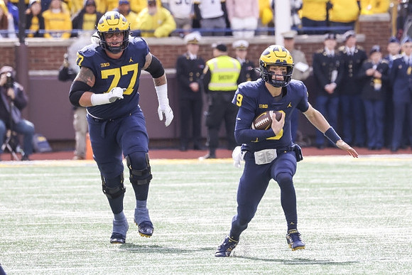 Trevor Keegan (77) and J.J. McCarthy (9)