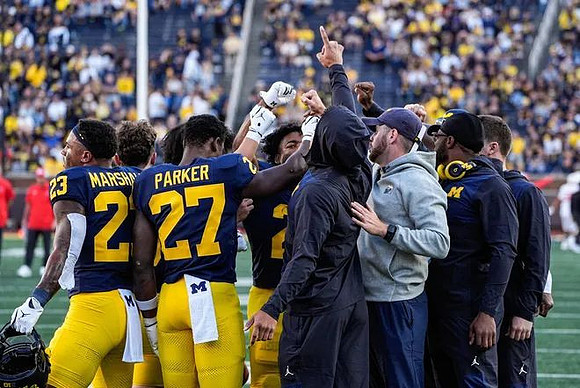 Cole Sullivan (23), Jayden Sanders (27), and Michigan Team
