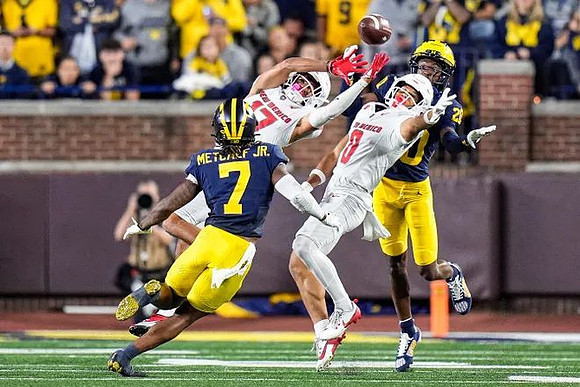 TJ Metcalf (7) and Jyaire Hill (20)