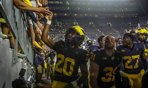 Jyaire Hill (20) and Michigan Team