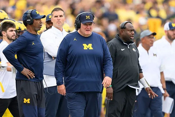 Acting Head Coach Biff Poggi and Michigan Team