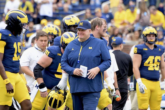 Bryce Underwood (19), Acting Head Coach Biff Poggi, and Crandall Quinn (46)