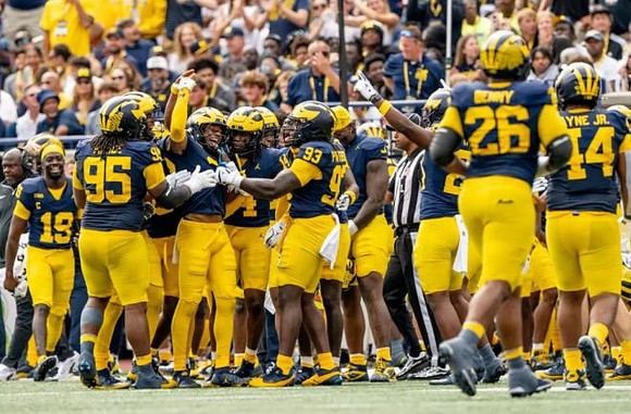 Elijah Dotson (22) and Michigan Team
