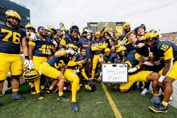Elijah Dotson (22) and Michigan Team
