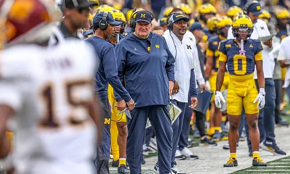 Acting Head Coach Biff Poggi and Michigan Team