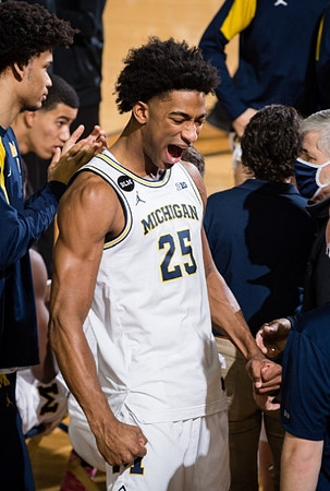 Jace Howard (25) and Michigan Team