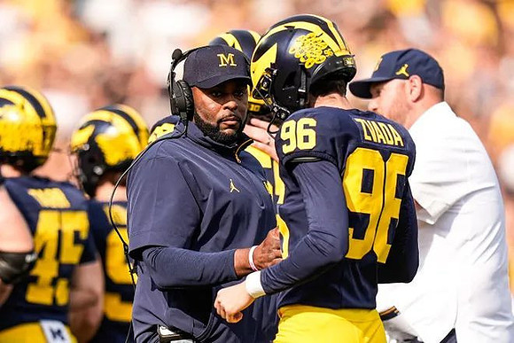 Sherrone Moore, Dominic Zvada (96), and Greg Tarr (45)