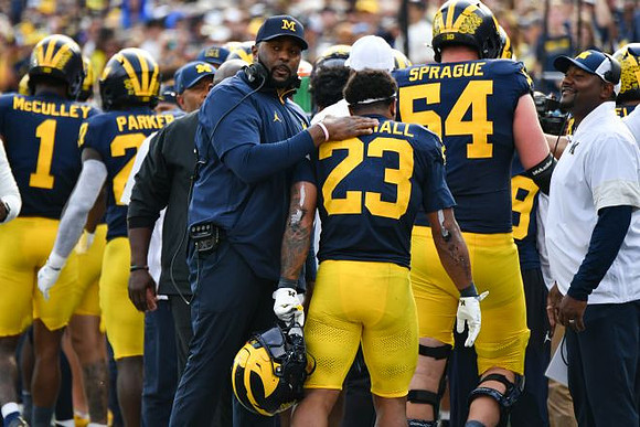 Donaven McCulley (1), Jasper Parker (27), Sherrone Moore, Jordan Marshall (23), Andrew Sprague (54), and Ron Bellamy