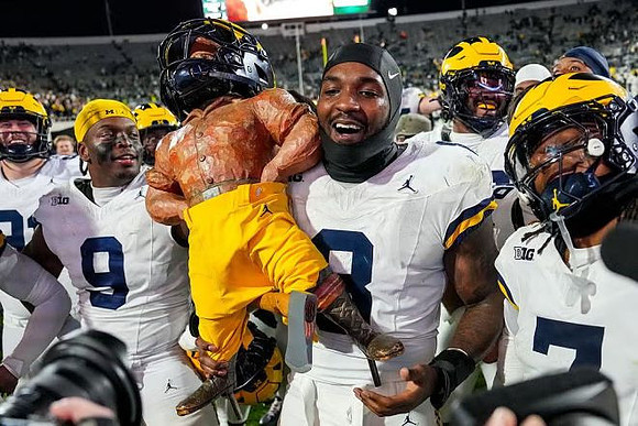 Derrick Moore (8), Michigan Team, and Paul Bunyan Trophy