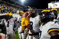 Jaishawn Barham (1), Derrick Moore (8), Michigan Team, and Paul Bunyan Trophy