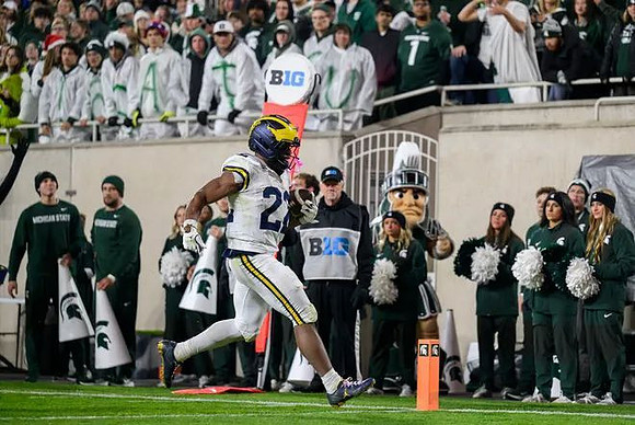 Justice Haynes (22) and Michigan State Mascot