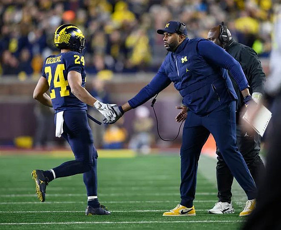 Bryson Kuzdzal (24), Sherrone Moore, and Tony Alford