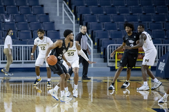 Mike Smith (12), Eli Brooks (55), and Chaundee Brown Jr. (15)