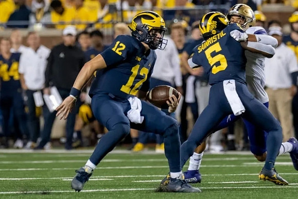 Cade McNamara (12), and Mike Sainristil (5)