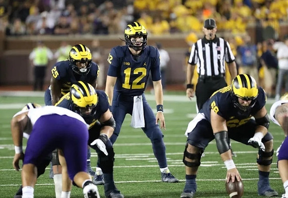 Hassan Haskins (25), Cade McNamara (12), and Andrew Vastardis (68)
