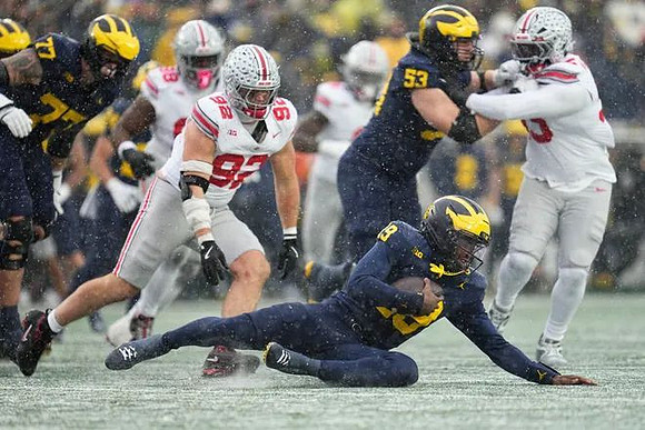 Blake Frazier (77), Bryce Underwood (19), and Jake Guarnera (53)
