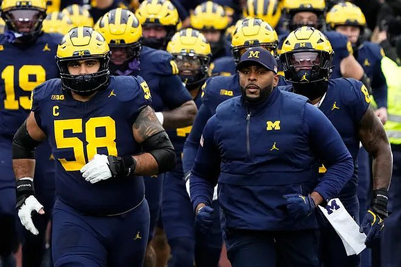 Giovanni El-Hadi (58), Sherrone Moore, and Michigan Team