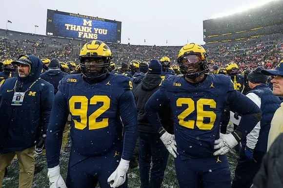 Ike Iwunnah (92), Rayshaun Benny (26), and Michigan Team