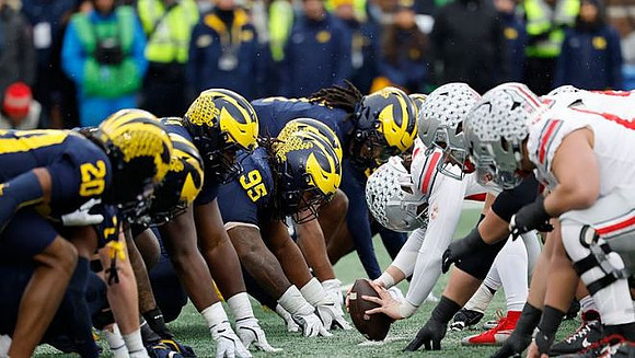 Jyaire Hill (20), Trey Pierce (95), and Michigan Team