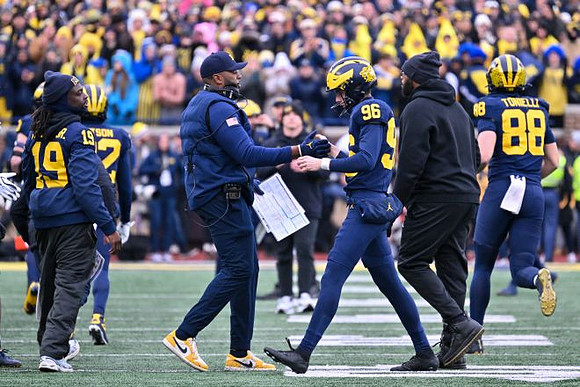 Rod Moore (19), Sherrone Moore, Dominic Zvada (96), and Deakon Tonielli (88)