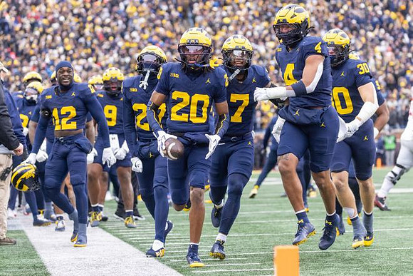 Jyaire Hill (20) and Michigan Team