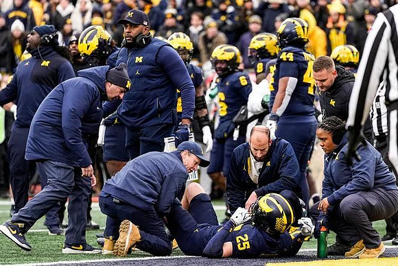 Sherrone Moore, Mason Curtis (25), and Michigan Team