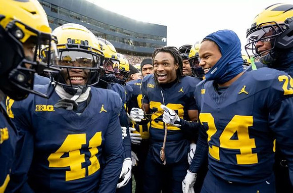 Jyaire Hill (20) and Michigan Team