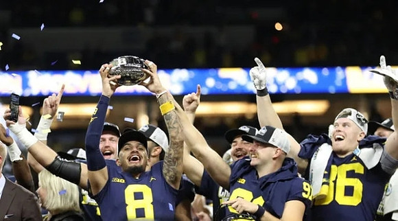 Ronnie Bell (8), Brad Robbins (91), Luke Schoonmaker (86), and Big Ten Championship Trophy