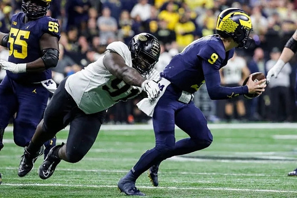 Olusegun Oluwatimi (55) and J.J. McCarthy (9)