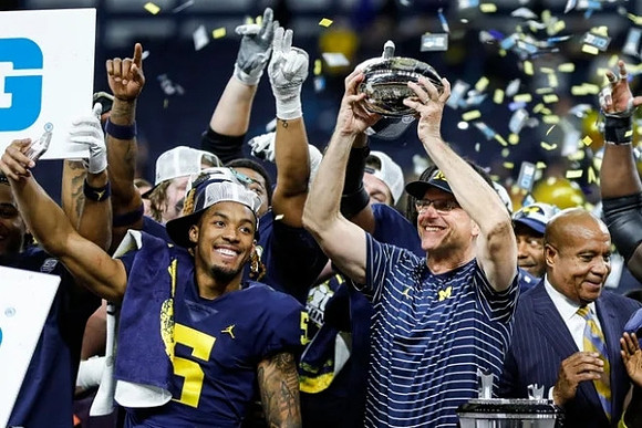 DJ Turner (5), Jim Harbaugh, and Big Ten Championship Trophy