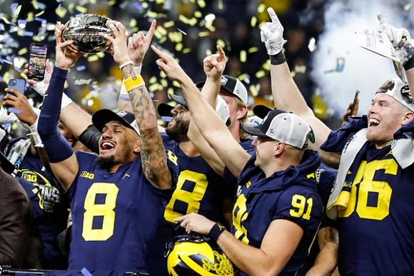 Ronnie Bell (8), Brad Robbins (91), Luke Schoonmaker (86), and Big Ten Championship Trophy