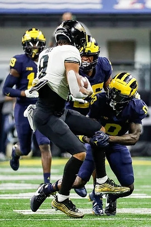 Rod Moore (19), Junior Colson (25), and Mike Sainristil (0)