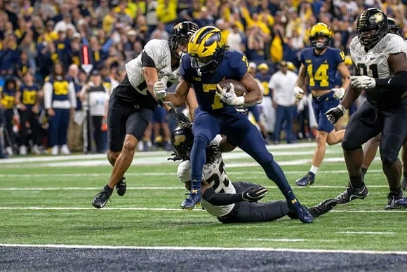 Donovan Edwards (7) and Roman Wilson (14)