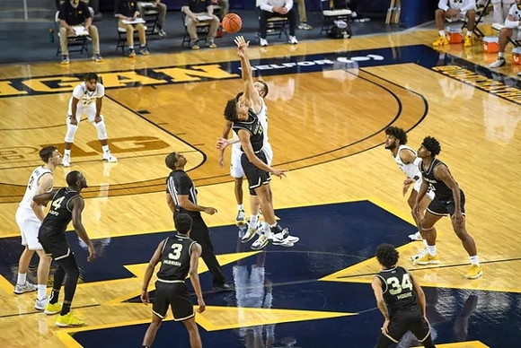Franz Wagner (21), Mike Smith (12), Eli Brooks (55), Hunter Dickinson (1), and Isaiah Livers (2)