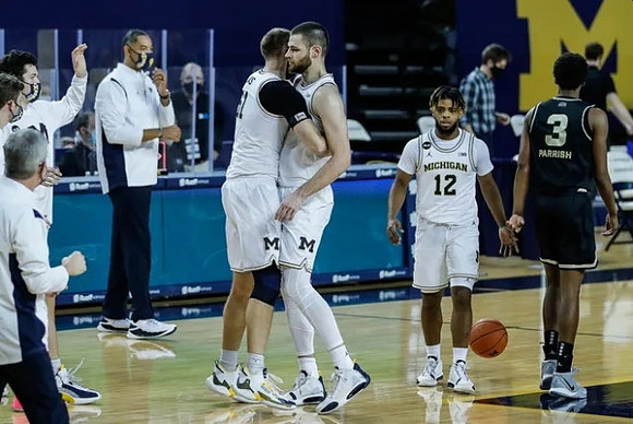 Juwan Howard, Austin Davis (51), Hunter Dickinson (1), and Mike Smith (12)