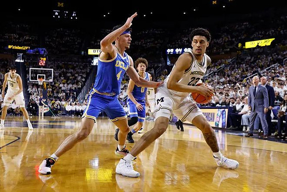 Aday Mara (15), Yaxel Lendeborg (23), Elliot Cadeau (3), and UCLA Head Coach Mick Cronin