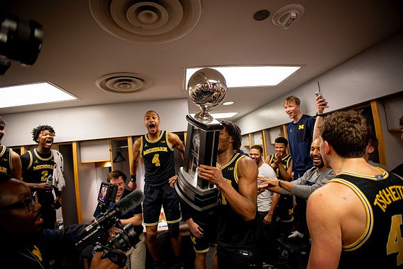 Morez Johnson Jr. (21), Big Ten Championship Trophy, and Michigan Team