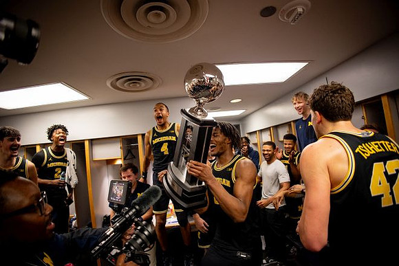 Morez Johnson Jr. (21), Big Ten Championship Trophy, and Michigan Team