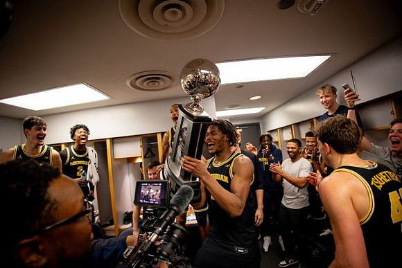 Morez Johnson Jr. (21), Big Ten Championship Trophy, and Michigan Team
