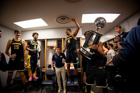 Morez Johnson Jr. (21), Big Ten Championship Trophy, and Michigan Team