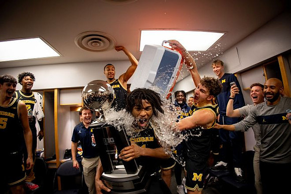 Morez Johnson Jr. (21), Big Ten Championship Trophy, and Michigan Team