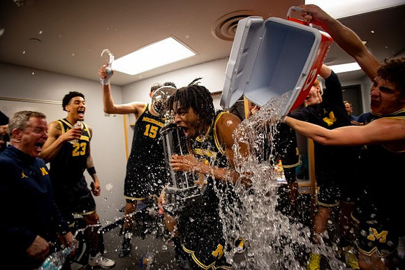 Dusty May, Morez Johnson Jr. (21), Big Ten Championship Trophy, and Michigan Team