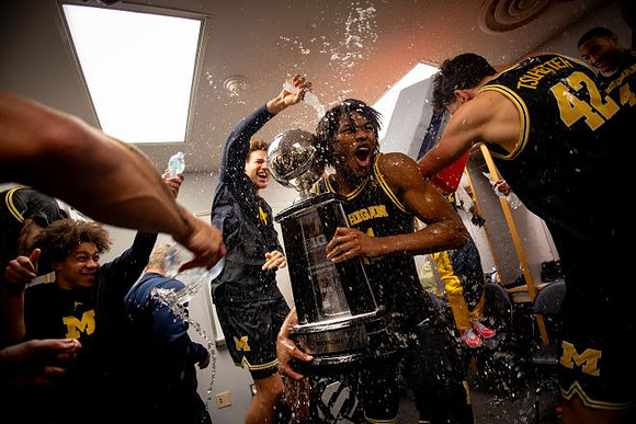 Morez Johnson Jr. (21), Big Ten Championship Trophy, and Michigan Team