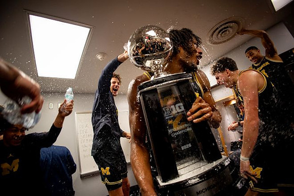 Morez Johnson Jr. (21), Big Ten Championship Trophy, and Michigan Team