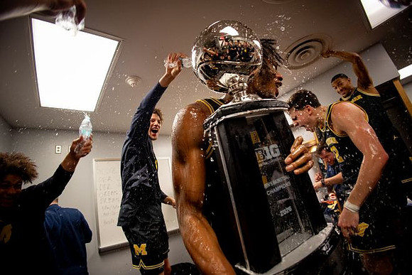 Morez Johnson Jr. (21), Big Ten Championship Trophy, and Michigan Team